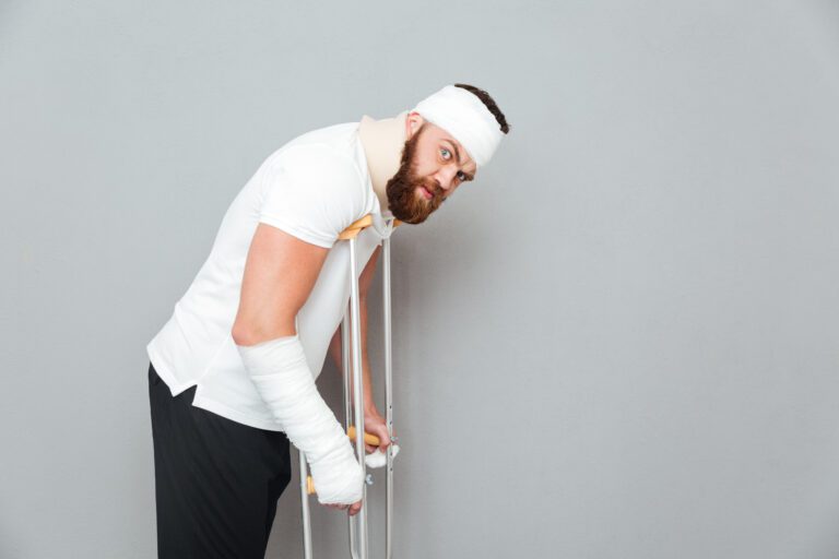 Injured Bearded Young Man Walking With Crutches